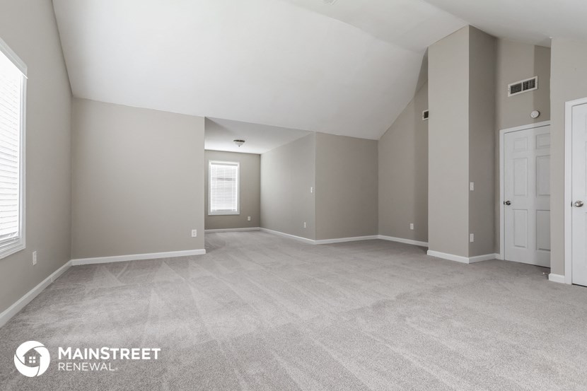 the spacious living room and dining room of an apartment