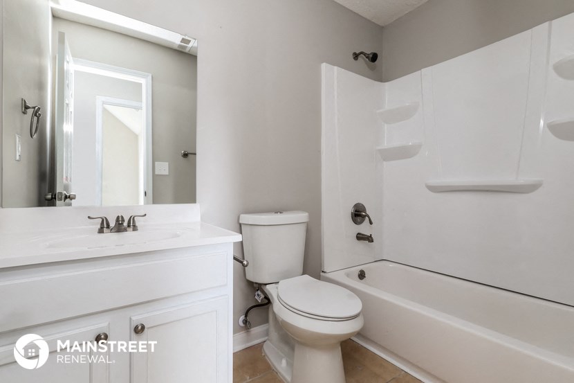 a bathroom with a toilet and a tub and a sink