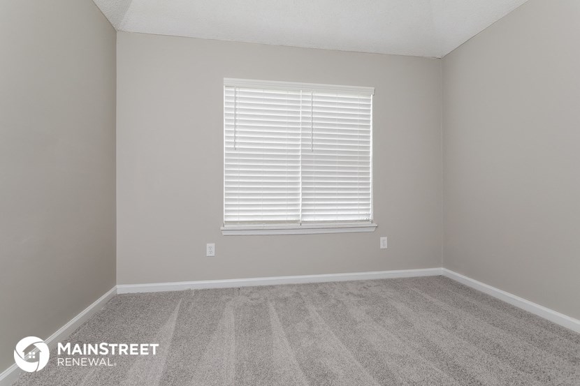 a room with a carpeted floor and a window