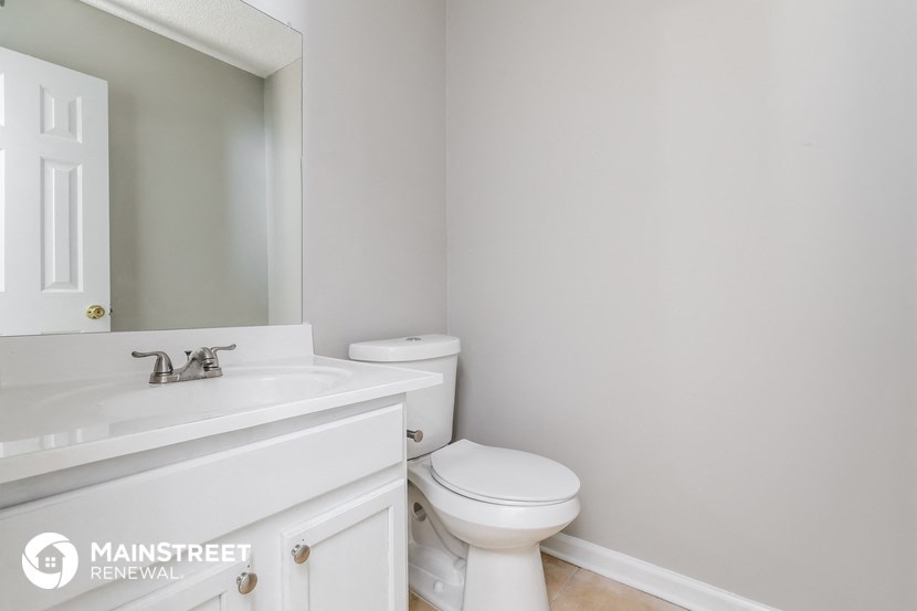 a bathroom with a sink toilet and a mirror