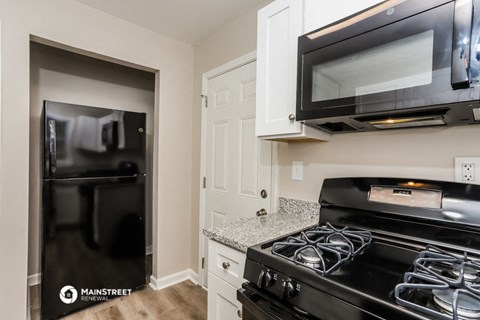 a kitchen with a stove and a microwave and a refrigerator