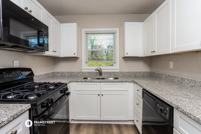 a kitchen with granite counter tops and white cabinets