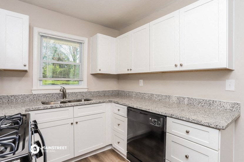 a kitchen with white cabinets and granite counter tops