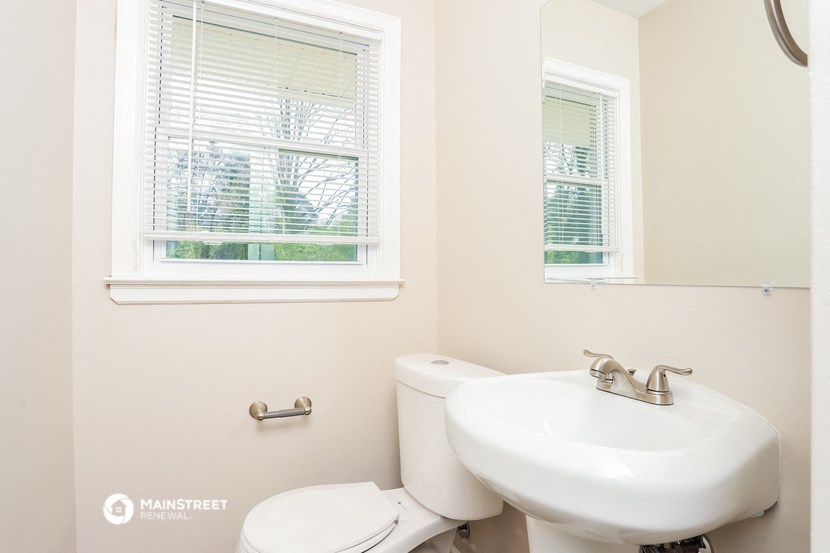 a bathroom with a sink and a toilet and a window