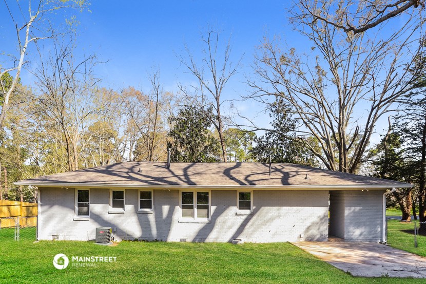 a white house with a tree shadow on the side of it