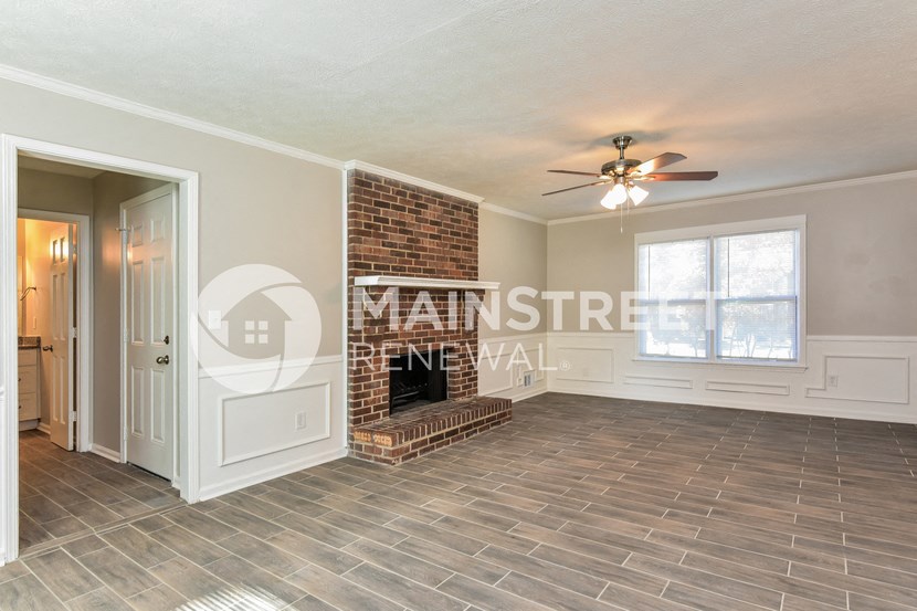 a living room with a fireplace and a ceiling fan