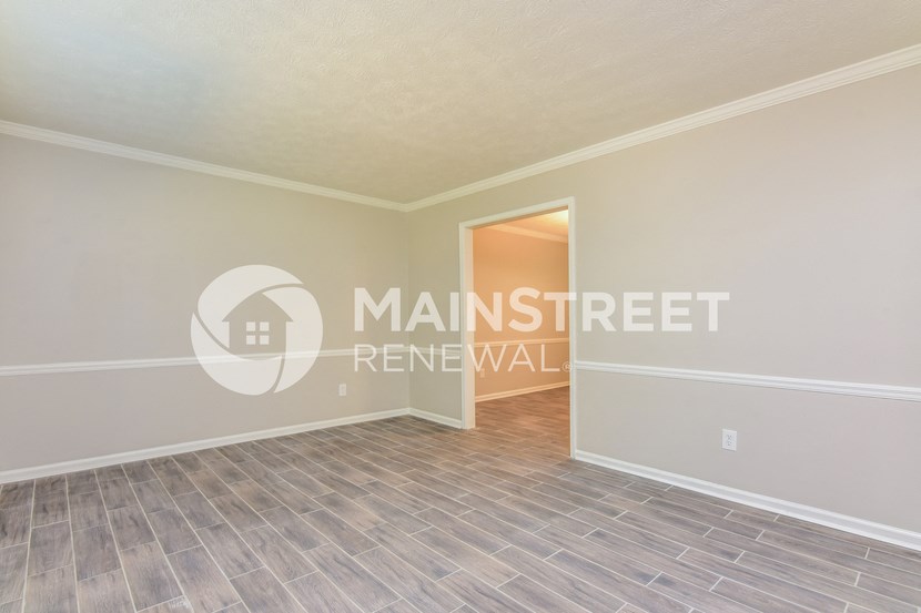 a bedroom with a door to a hallway and a hard wood floor