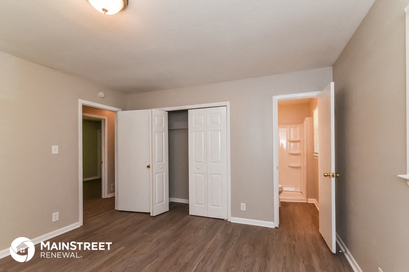 the living room of an apartment with wood floors and white doors