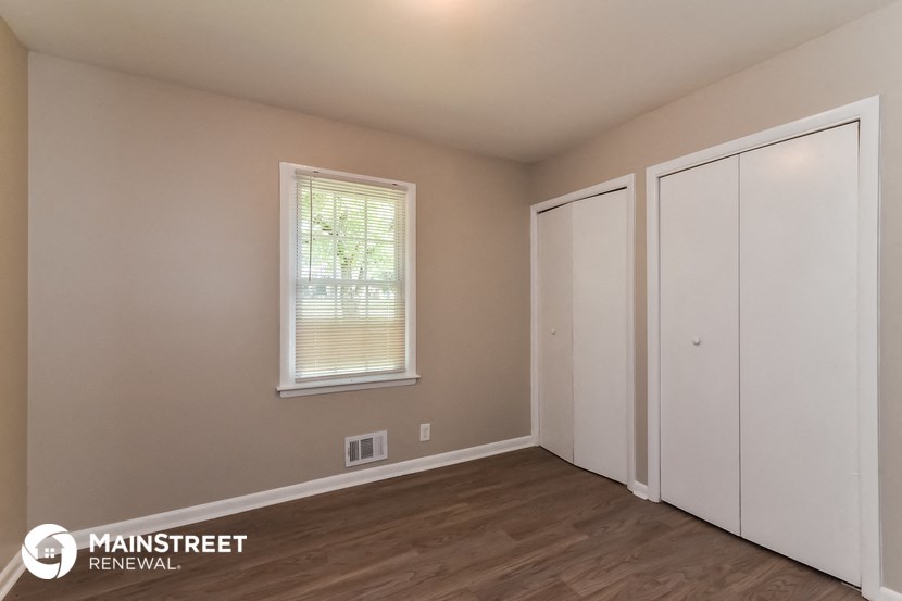 the upstairs bedroom with two closets and a window