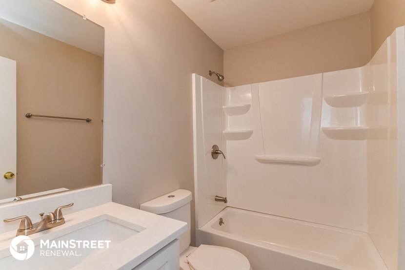 a bathroom with a toilet sink and shower and a tub