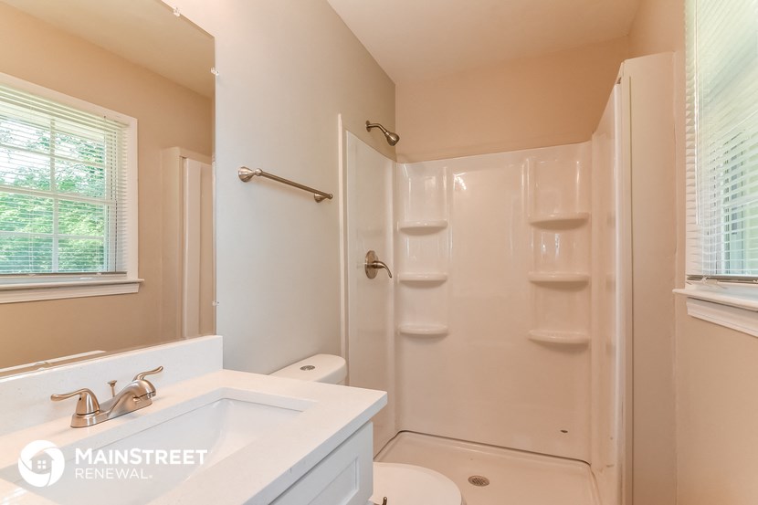 a bathroom with a shower and a sink and a toilet