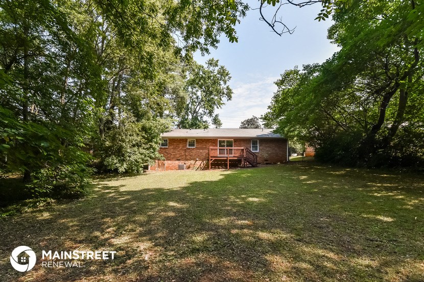 a small brick house with a yard and trees