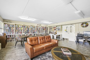 Sundale-Library3 library with comfortable seating, many shelves of books, and large reading table - Photo Gallery 6
