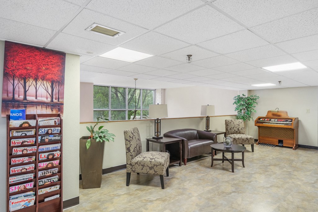 sitting area with magazine rack, couch and chairs, and piano