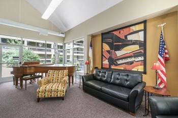 Sundale-Community-Room2 community room with large painting, couch, chairs, American flag, and piano - Photo Gallery 5