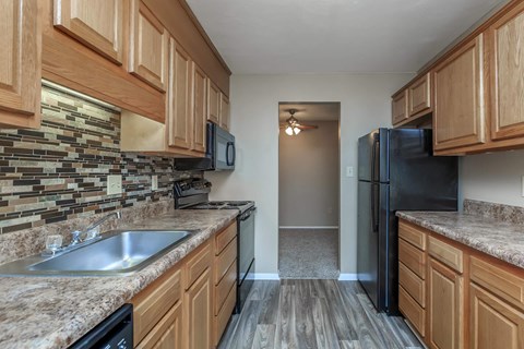 a kitchen with granite counter tops and a black refrigerator