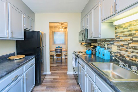 a kitchen with stainless steel counter tops and a black refrigerator