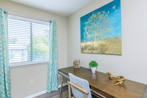 a desk and chair in a room with a window