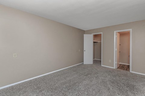 a bedroom with a carpeted floor and a door to a closet