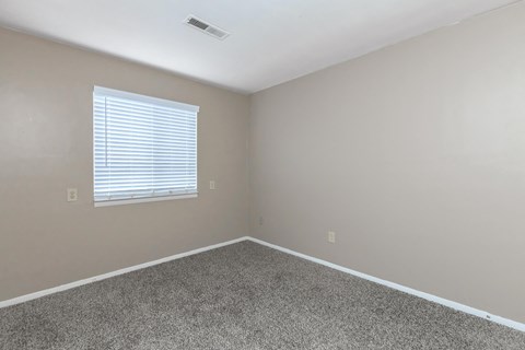 an empty room with carpet and a window