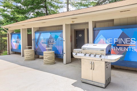 a patio with a grill and a barbecue grill in front of a building