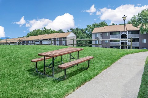 a picnic table and benches in front of an apartment building