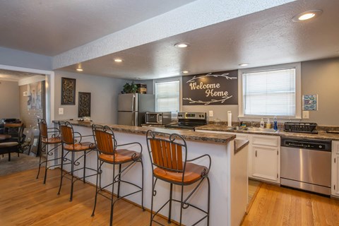 a kitchen with a bar and a counter top with chairs