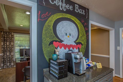 a coffee bar with a painting of a penguin on the wall