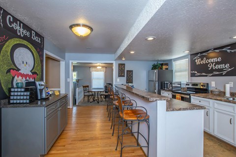 a kitchen with a bar and a counter with chairs