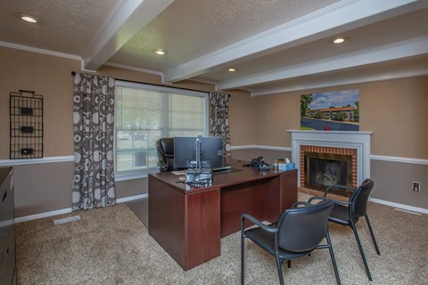 a home office with a fireplace and a desk