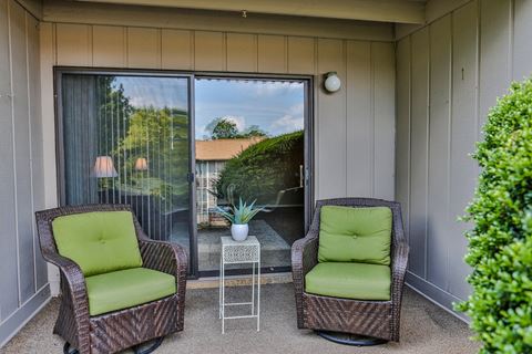 a patio with two chairs and a table in front of a window
