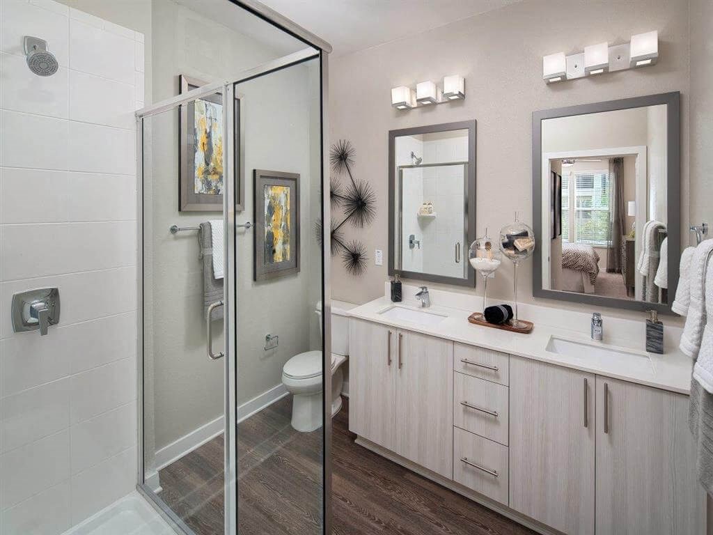 Glass enclosed shower and double vanity sinks