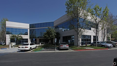 an office building with cars parked in a parking lot