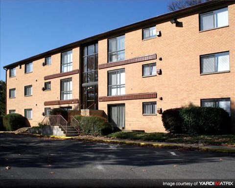 a large brick apartment building with stairs and bushes
