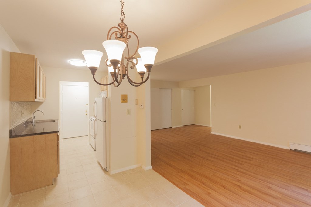 a kitchen and dining room with a wood floor and a chandelier