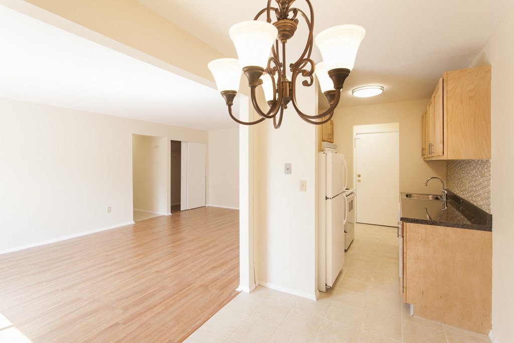 an empty kitchen and living room with a chandelier