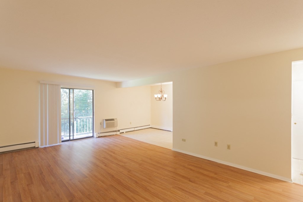 an empty living room with a wood floor and a sliding glass door