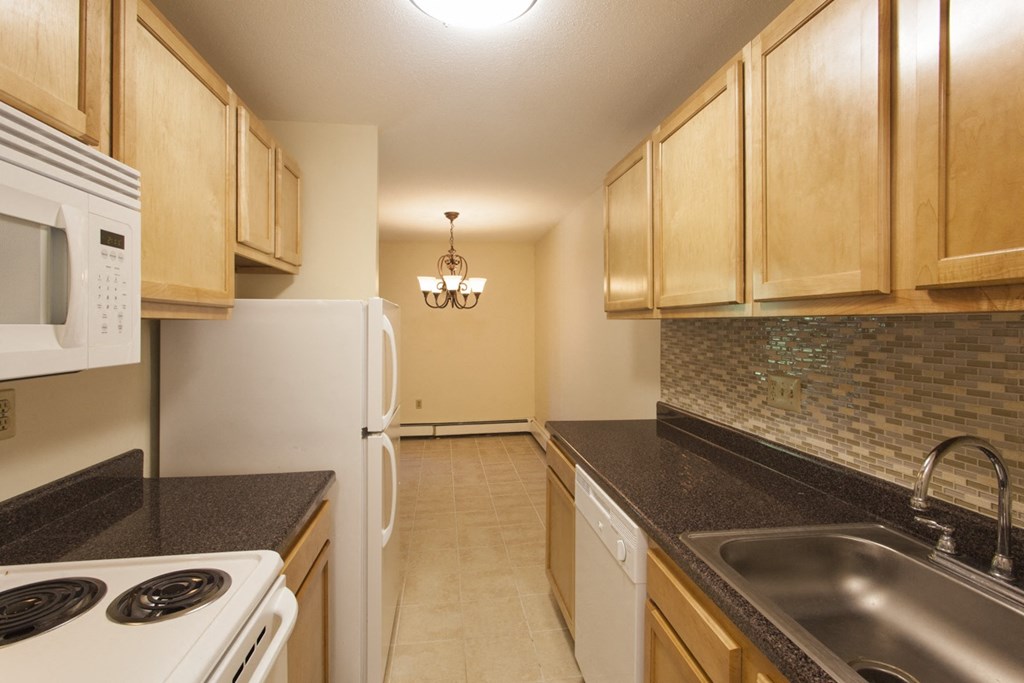 a kitchen with white appliances and granite counter tops