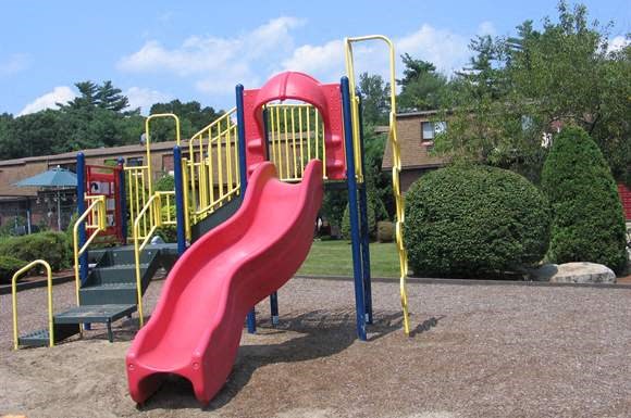 a slide at a playground with a red slide