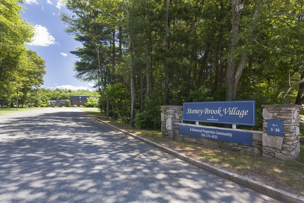 a sign for sandy brook village at the side of a road