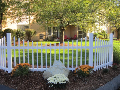 a white fence in the front yard of a house