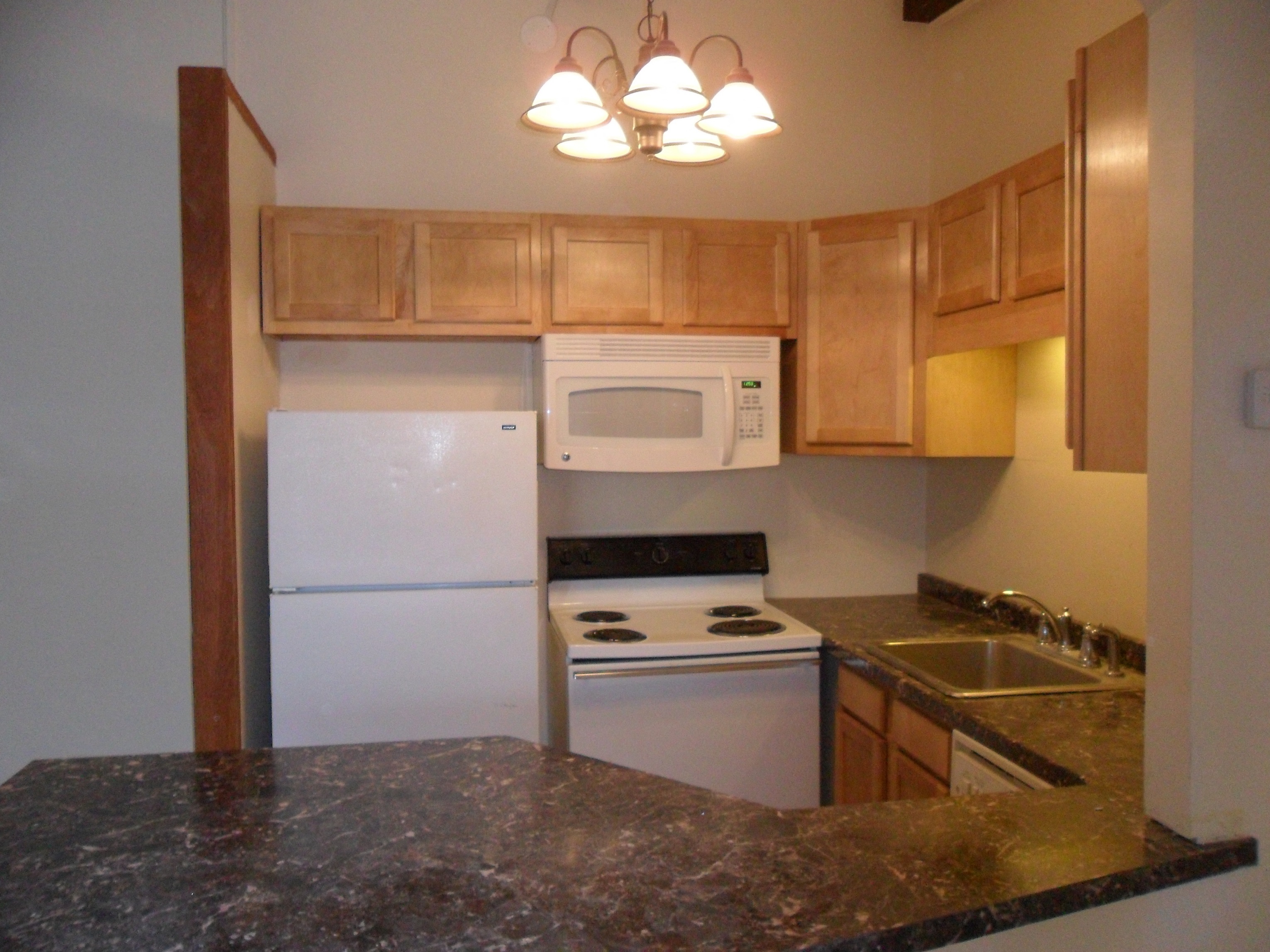 a kitchen with white appliances and granite counter tops