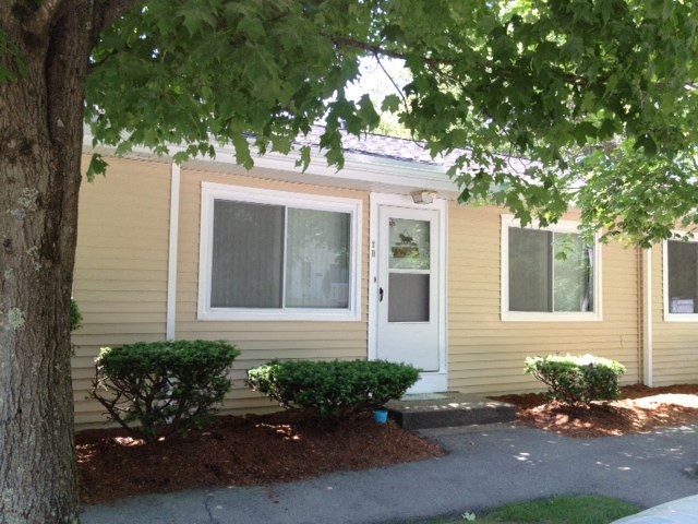 the front of a yellow house with a white door