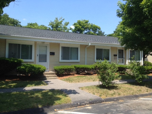 a white house with a sidewalk in front of it