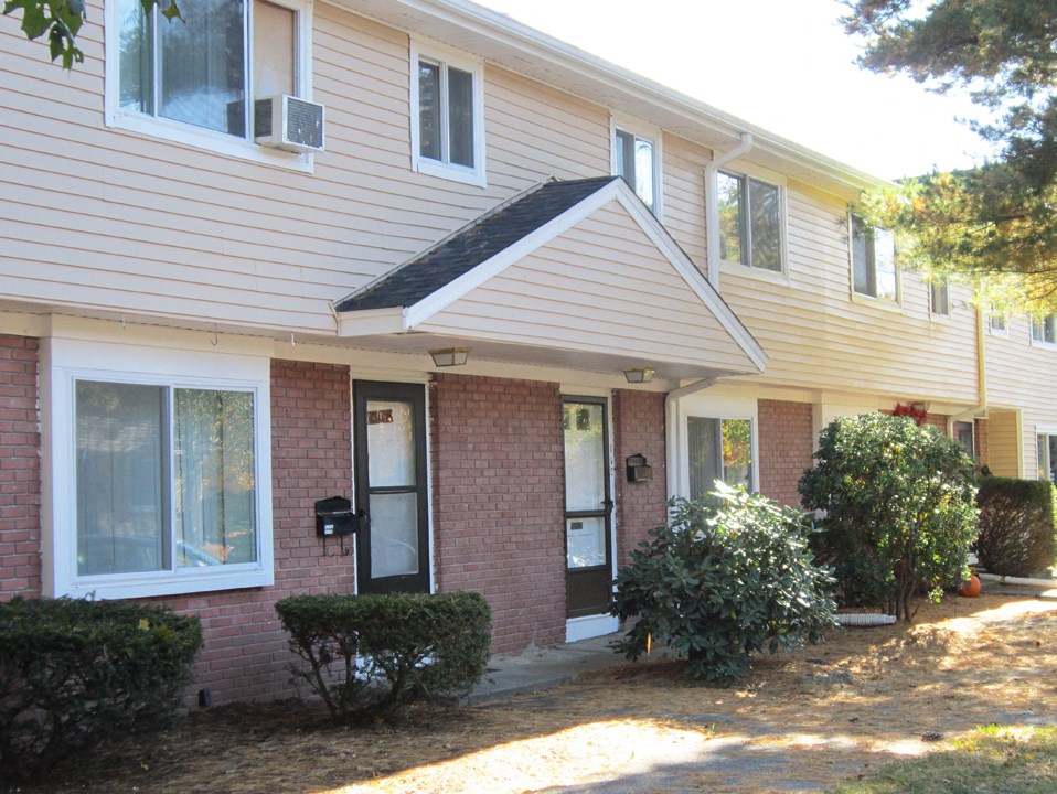 the front of a brick house with a black door
