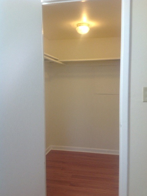 an empty room with a ceiling light and a wooden floor