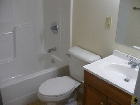 a bathroom with a toilet and a tub and a sink
