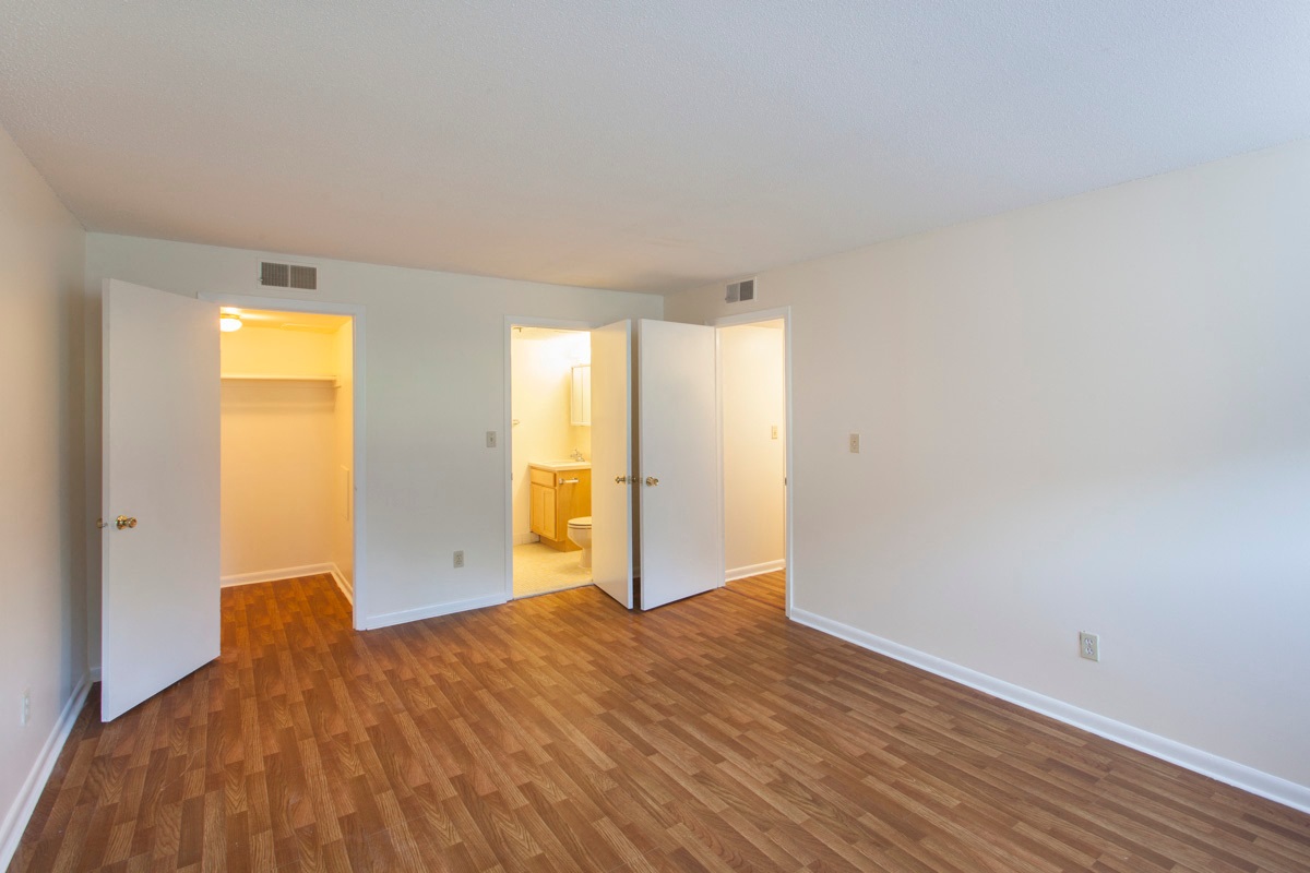 an empty living room with a hard wood floor and white walls