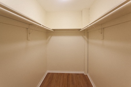 a white room with a hard wood floor and a closet