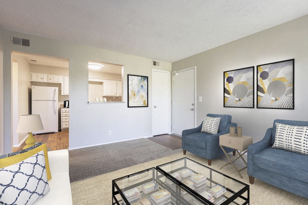 the living room of an apartment with a couch and chair and a glass coffee table